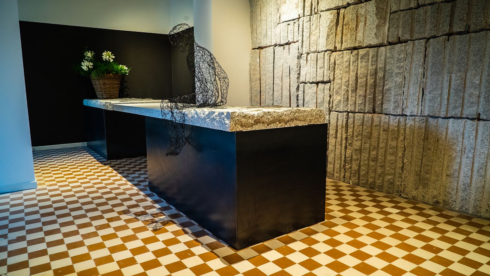 DaidiRooms — isola in laccato nero su cementine, parete in pietra a vista